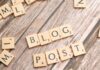 Drewniane klocki układające się w napis Blog Post na drewnianym tle