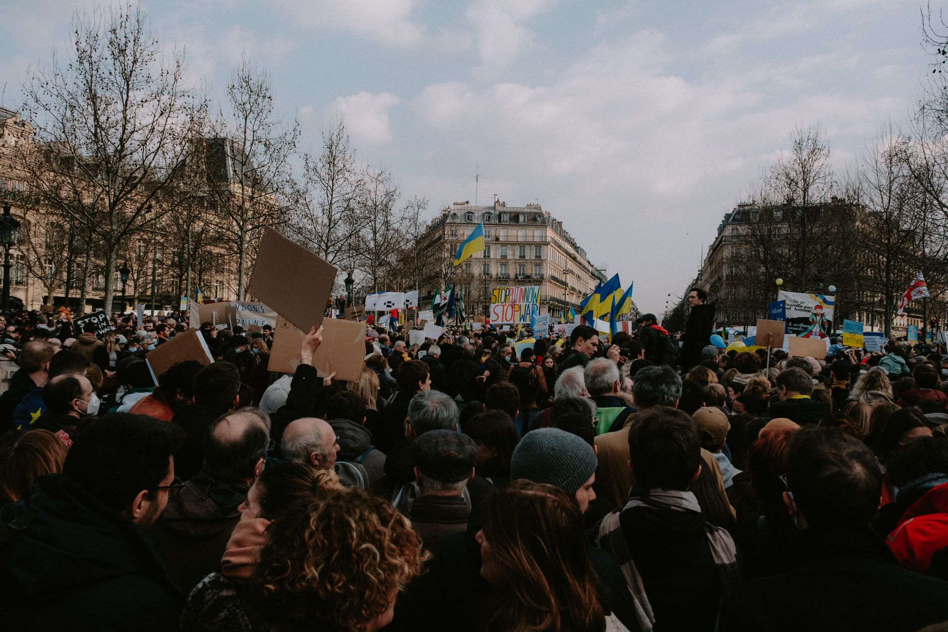 Młodzi demonstranci na ulicznym proteście z flagami i transparentami